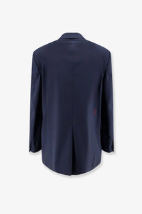 Back side of a navy blue amaránto men’s virgin wool blend tailored blazer with subtle red embroidered logo on pocket