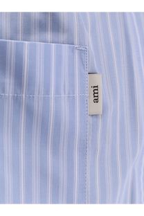 Light blue and white striped cotton shirt with beige ami brand tag paired with ami paris men’s blue cotton bermuda shorts