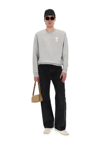 A beige suede crossbody bag with minimalist design and small gold-tone logo paired with ami paris men’s large fit black jeans