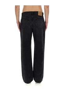 Ami Paris men’s jeans large fit black wide-leg denim with faded wash and brown leather brand patch on the back waistband