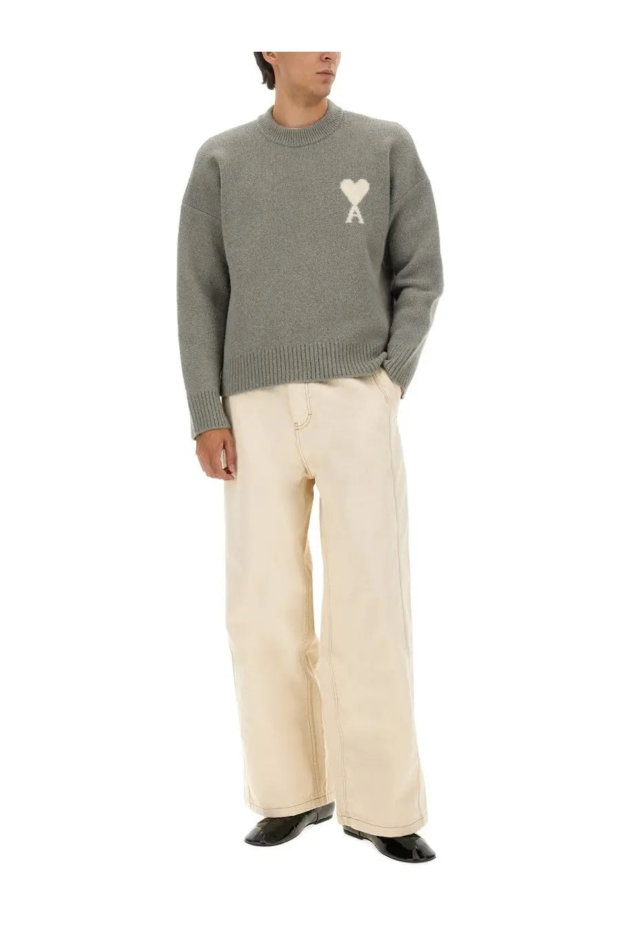 Gray knit sweater with white heart logo on chest paired with Ami Paris men’s wide fit white jeans