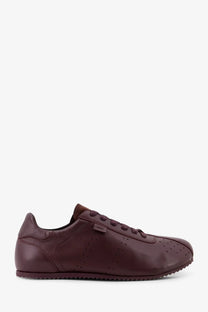 Ami Paris men’s leather low top sneaker in burgundy with perforated detailing and a textured rubber sole