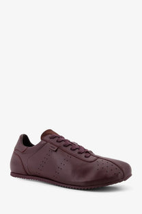 Ami Paris men’s leather low top sneaker in burgundy with perforated detailing and classic sleek design