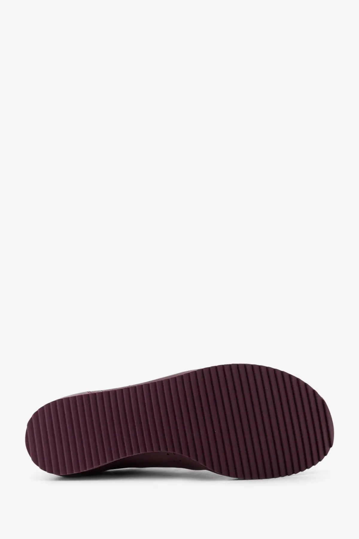 The sole of a dark burgundy rubber sole with vertical ridges on ami paris men’s leather low top pink sneakers