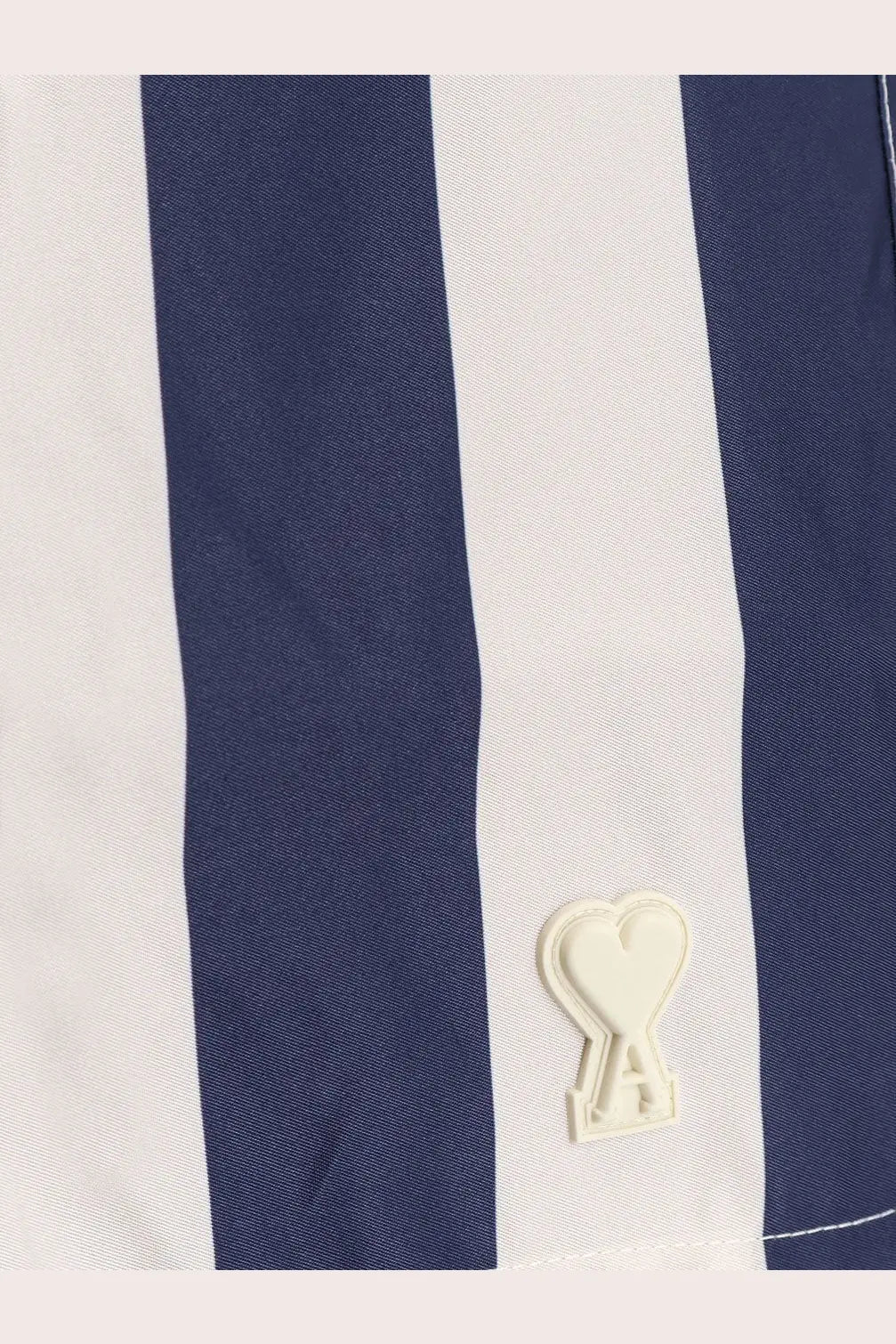 Ami Paris men’s nylon swim shorts in white with navy blue stripes and a cream heart-shaped logo patch on the side