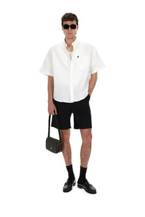 Ami paris men’s shorts elasticizzati with black leather crossbody bag featuring gold-tone hardware and minimalist logo detail