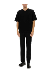 Black ami paris men’s straight fit pants paired with a black short-sleeved crew neck t-shirt with embroidered logo