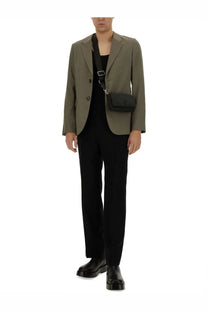Black crossbody bag with minimalist design and subtle logo detail complementing ami paris men’s green two button jacket