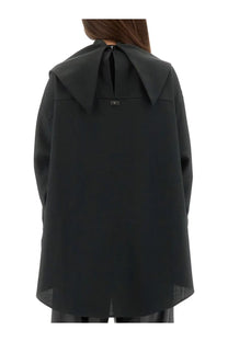 Black oversized cape style top with wide collar and subtle back zipper detail shown from the back side