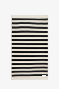 Ami Paris unisex cotton beach towel with bold black and cream horizontal stripes in a rectangular shape