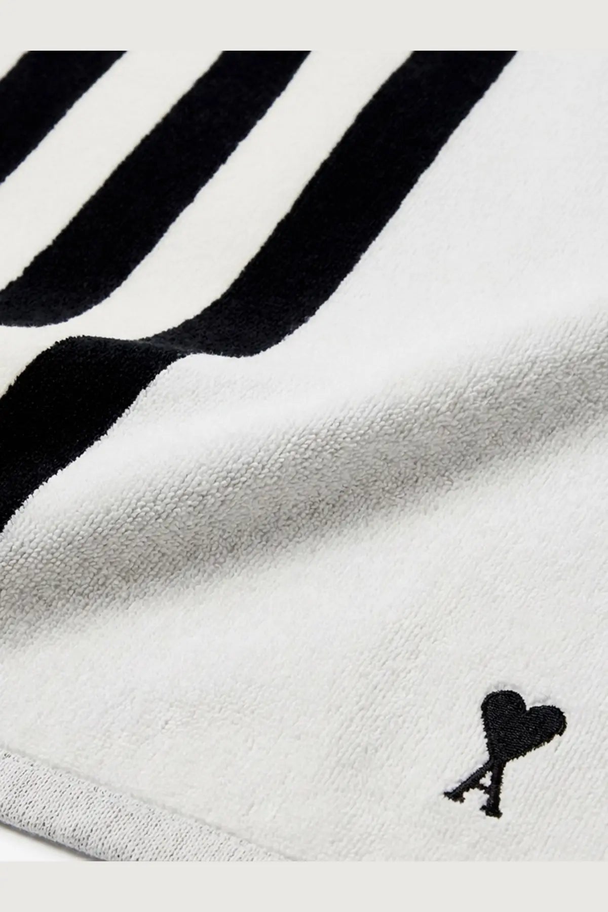 Ami Paris unisex cotton beach towel in white with bold black stripes and a small embroidered heart logo