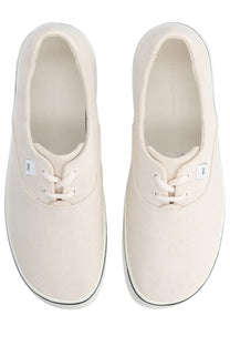 Cream-colored canvas Ami Paris unisex tennis sneaker with black rubber soles and white laces