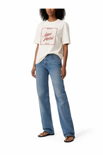 Ami paris women’s white cotton t-shirt with red cursive logo and rectangular border worn over blue wide-leg jeans