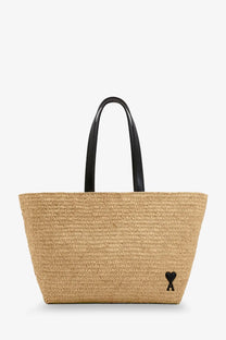 Beige woven straw tote bag with black leather handles and a small black heart logo by ami paris