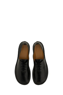 Ami Paris women’s black leather lace-up shoes with white stitching and tan lining showing the back side