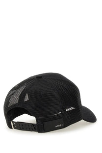 Back side of amiri black mesh trucker hat with solid black brim and adjustable strap showing brand label