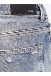 Back side of amiri men’s destroyed effect light-wash denim jeans with distressed patch and brand label on pocket