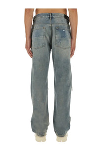 Washed blue denim amiri men’s jeans with relaxed fit and distressed details in cotton material