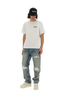 Mens amiri jeans mx1 blue paired with white t shirt featuring subtle black logo on the chest