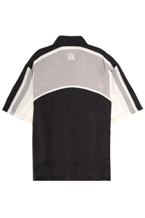 Amiri men’s ma quad panel black polo shirt with short sleeves, subtle textured pattern, and contrasting sleeve stripes