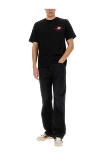 Black short-sleeved t-shirt with small embroidered logo paired with amiri men’s straight leg black jeans