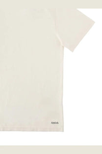 Cream-colored cotton amish supplies men’s t-shirt with subtle black amish logo embroidered at bottom hem