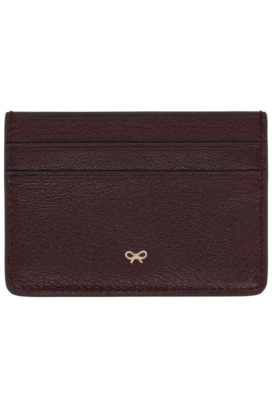 Anya Hindmarch women’s burgundy leather card holder with pebbled texture and gold bow emblem at bottom center