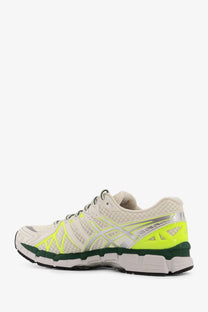 Asics men’s gel kayano low top mesh sneakers in white with neon yellow and silver accents designed for running