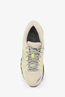 A sleek off-white ASICS men’s gel kayano low top mesh sneaker with neon yellow accents and breathable mesh upper