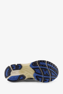 Back view of asics mens gel nimbus mesh sneakers with blue and black rubber sole and beige midsole featuring logo