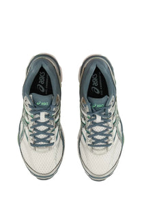 White and gray asics gel-cumulus 18 running shoes with mesh upper green accent stripes and black branding on tongue