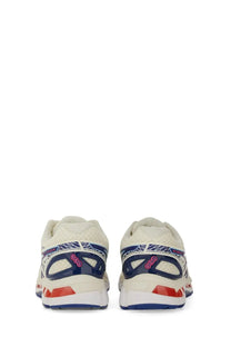 Cream-colored asics unisex gel kayano sneaker with navy blue and red mesh upper and geometric detailing