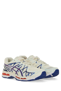 Cream-colored asics unisex gel kayano sneaker with blue and red accents breathable mesh upper and supportive midsole