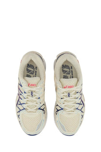 Cream-colored asics unisex gel kayano sneaker with navy and gray mesh upper featuring signature branding