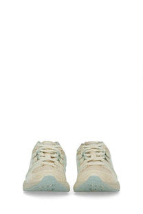 Cream-colored ASICS unisex Gel Nimbus sneakers with a textured upper and light blue rubber soles