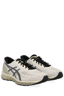 Asics unisex gel quantum sneaker with white mesh upper, black laces, gray branding, and cushioned sole