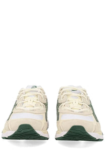 Cream-colored asics unisex sneaker gel nyc white with dark green accents and a textured rubber sole