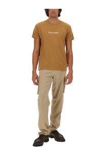 A mustard yellow short sleeve t shirt with white un attimo text paired with ASPESI men’s beige cargo pants