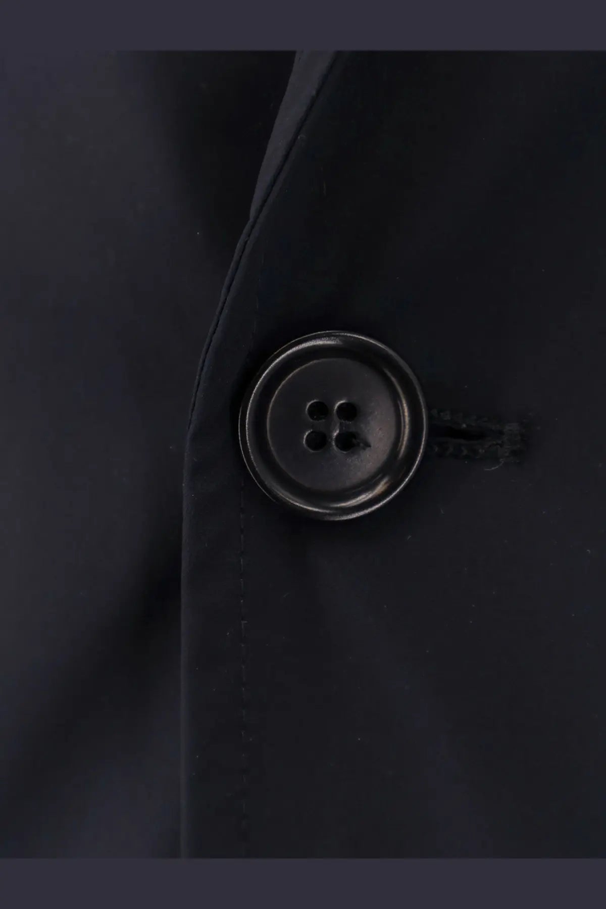 Black round button with four holes and metallic sheen on aspesi men’s paperino stretch nylon blue blazer