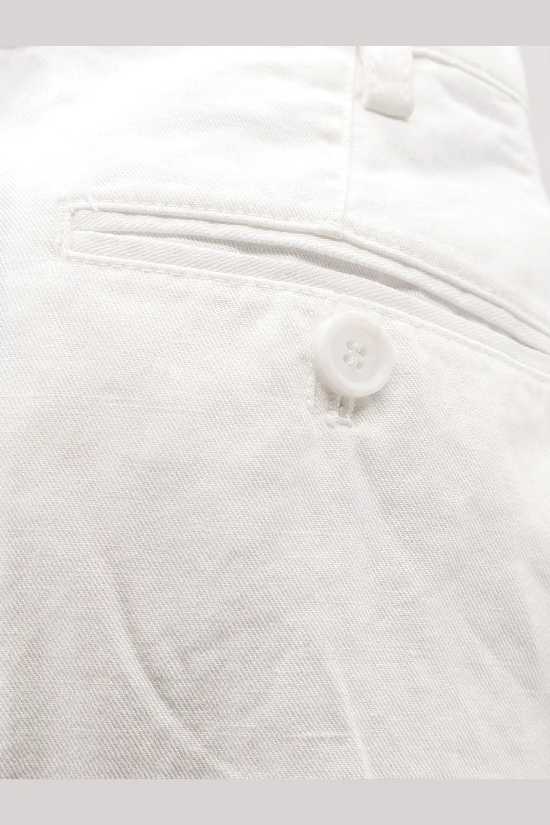 White button with four holes sewn on light-colored fabric of aspesi women’s cotton and linen shorts white