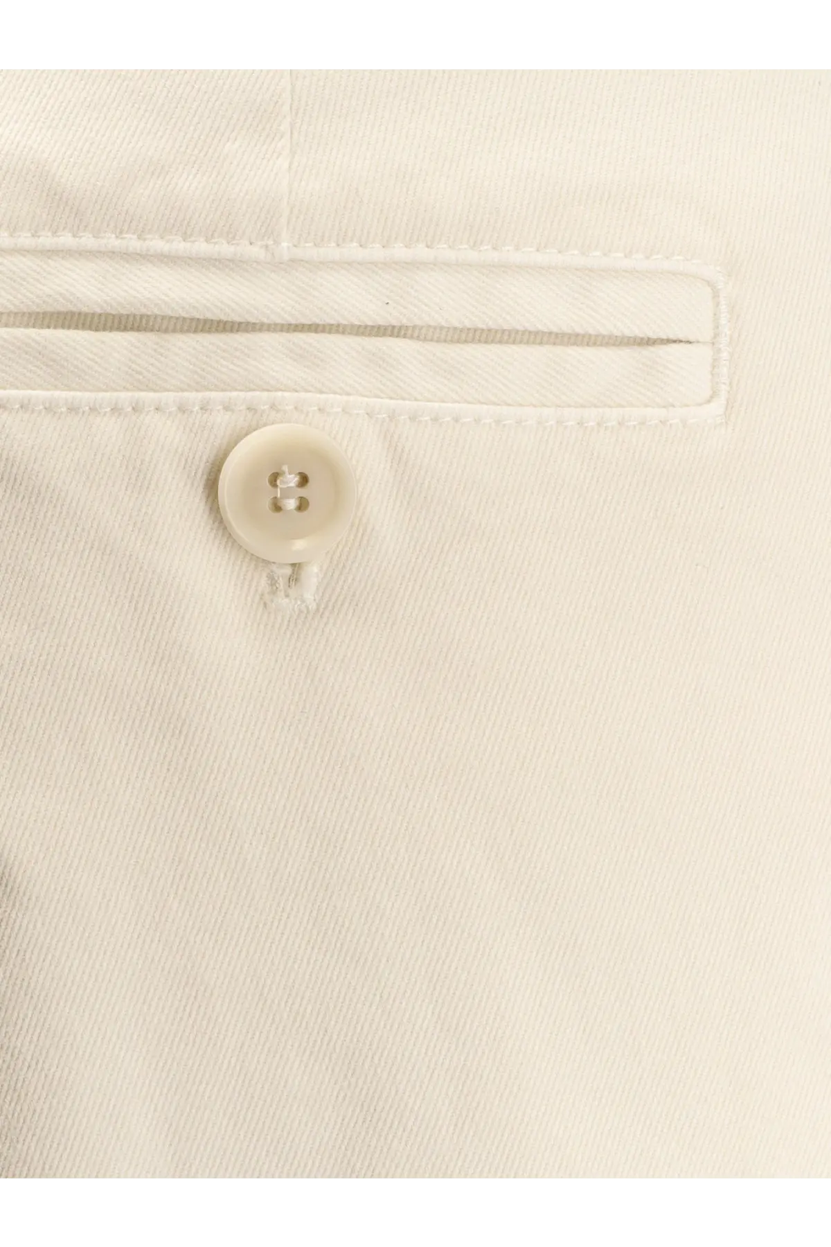 A cream-colored button with two holes neatly stitched on light-wash denim of aspesi women’s cotton trousers white