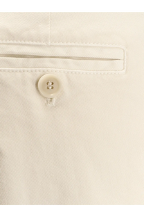 A cream-colored button with two holes neatly stitched on light-wash denim of aspesi women’s cotton trousers white