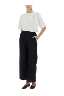 Black wide-leg trousers with elastic waistband and side pockets paired with aspesi women’s white shirt