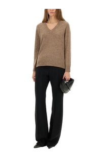A sleek black leather clutch with minimalist design and subtle stitching paired with aspesi women’s beige wool blend sweater