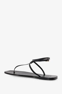 Black leather thong sandal with minimalist design and small metallic buckle on the ankle strap by ATP Atelier