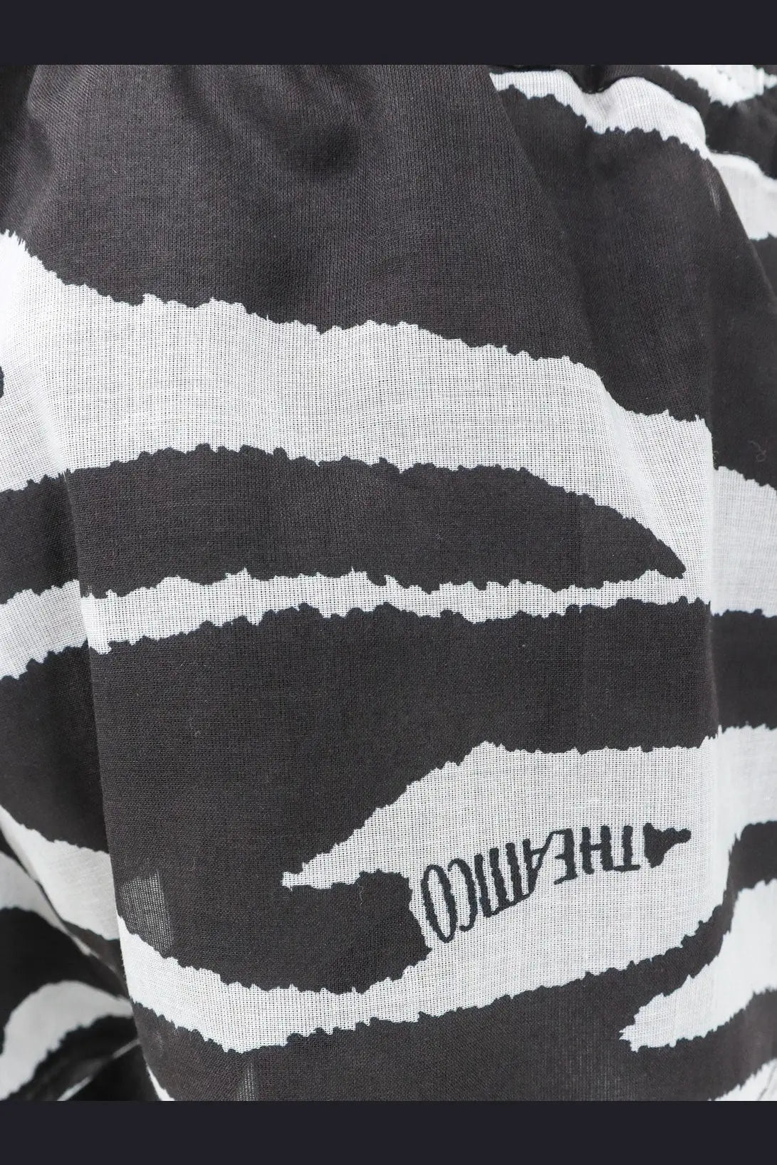 The attico women’s cotton beach shorts black paired with a black and white zebra-striped scarf with a textured weave