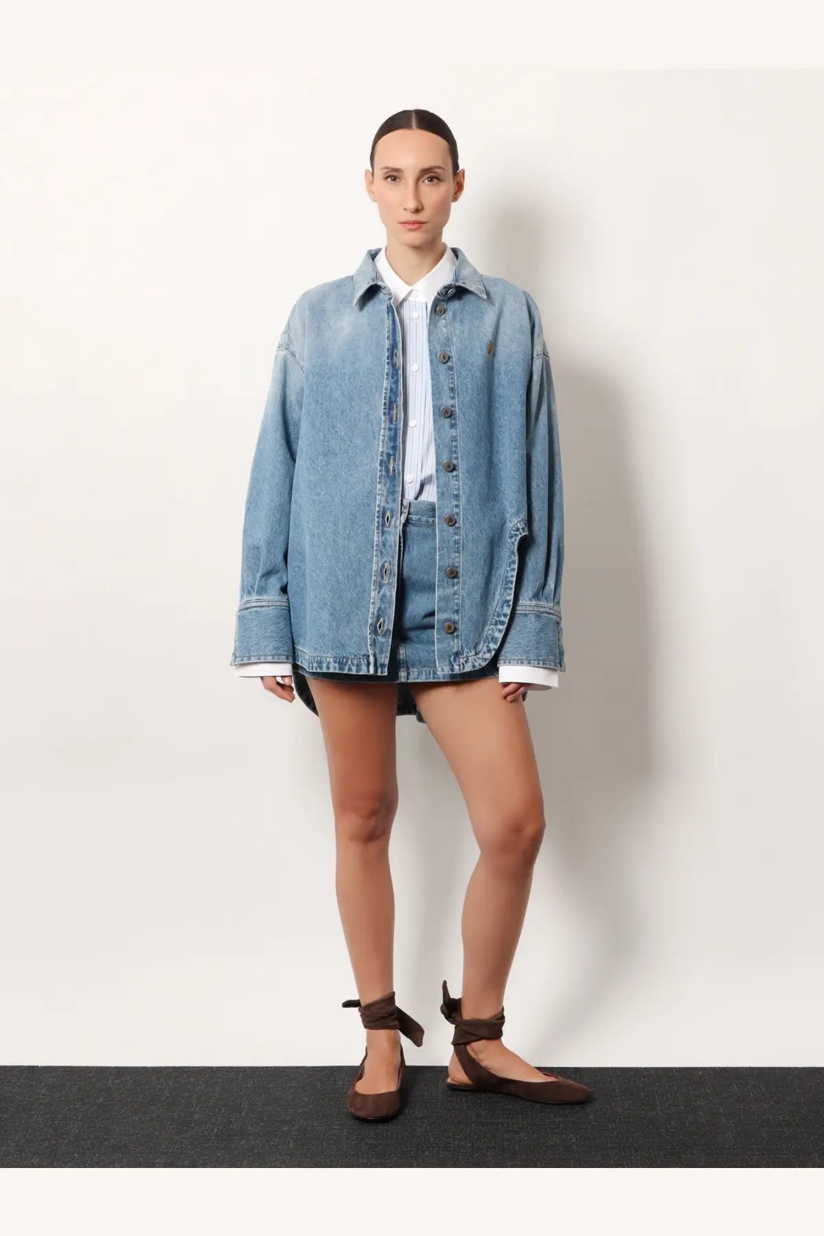 Light-wash denim jacket with relaxed oversized fit and button-front closure paired with the attico blue denim skirt