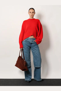 A rich brown leather handbag with structured shape and top handles paired with The Attico women’s blue jeans