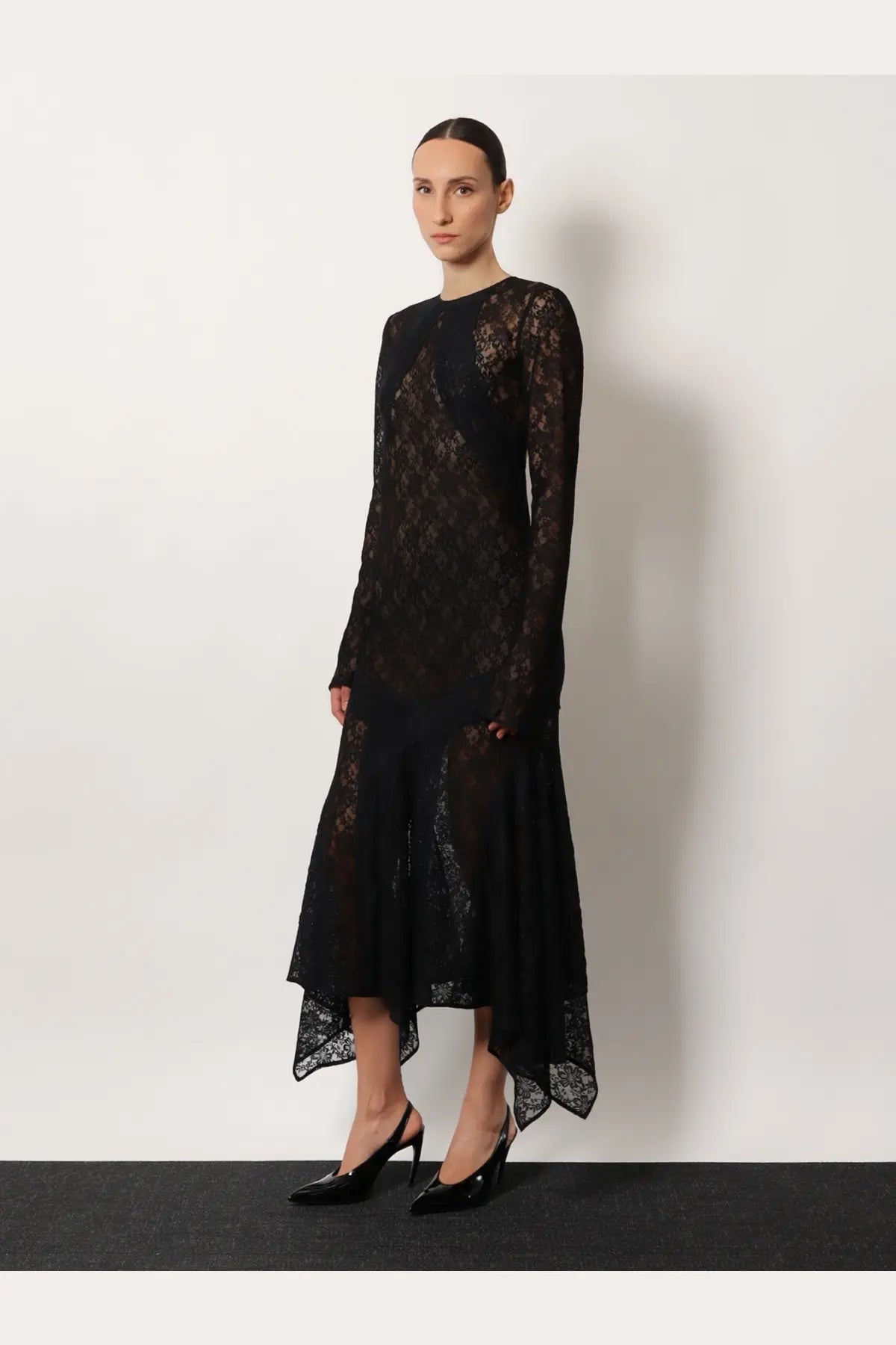 The Attico women’s black lace dress features long sleeves and an asymmetrical hemline in elegant lace fabric