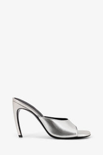 The attico women’s laminated leather betta sandals in silver feature a sleek metallic mule heel with a black insole